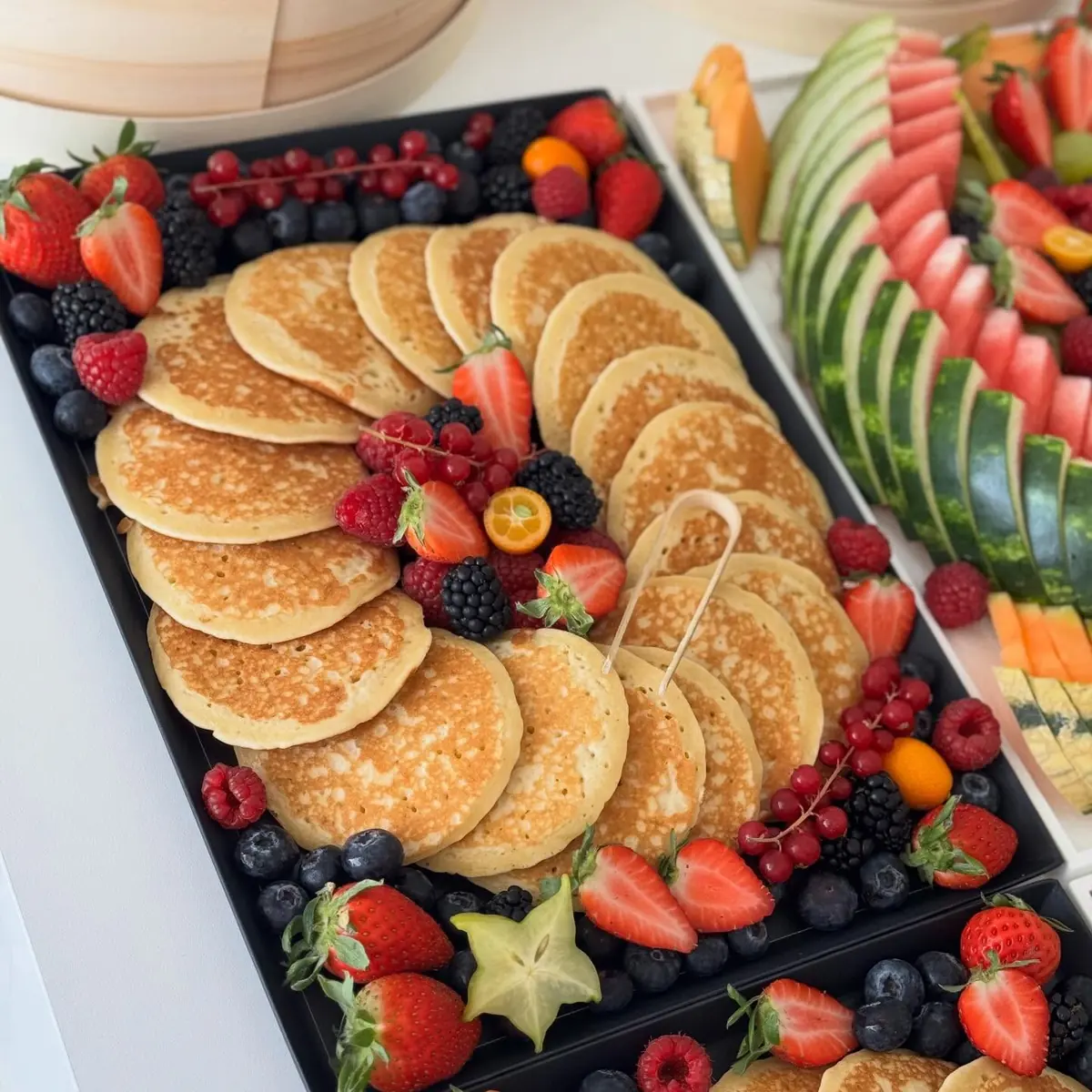Pancakes disposés en couronne avec fraises, myrtilles et framboises